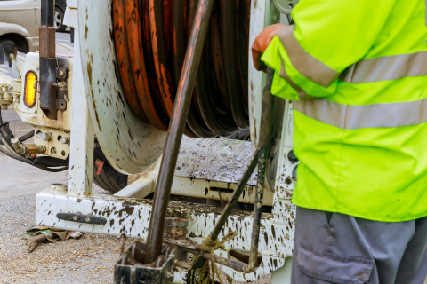 Machine for cleaning sewer wells in the a town street.