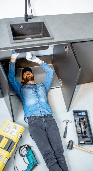 Man repairing kitchen plumbing